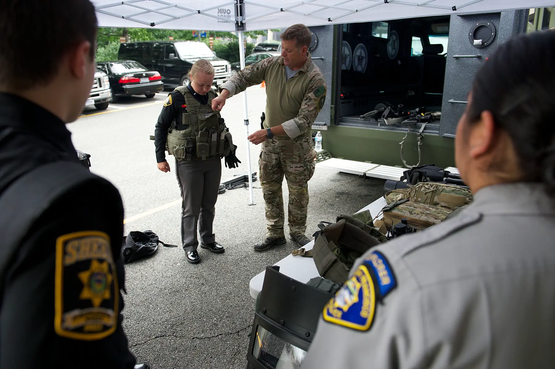Officer demonstrating a tactical vest to uniformed law-enforcement trainees