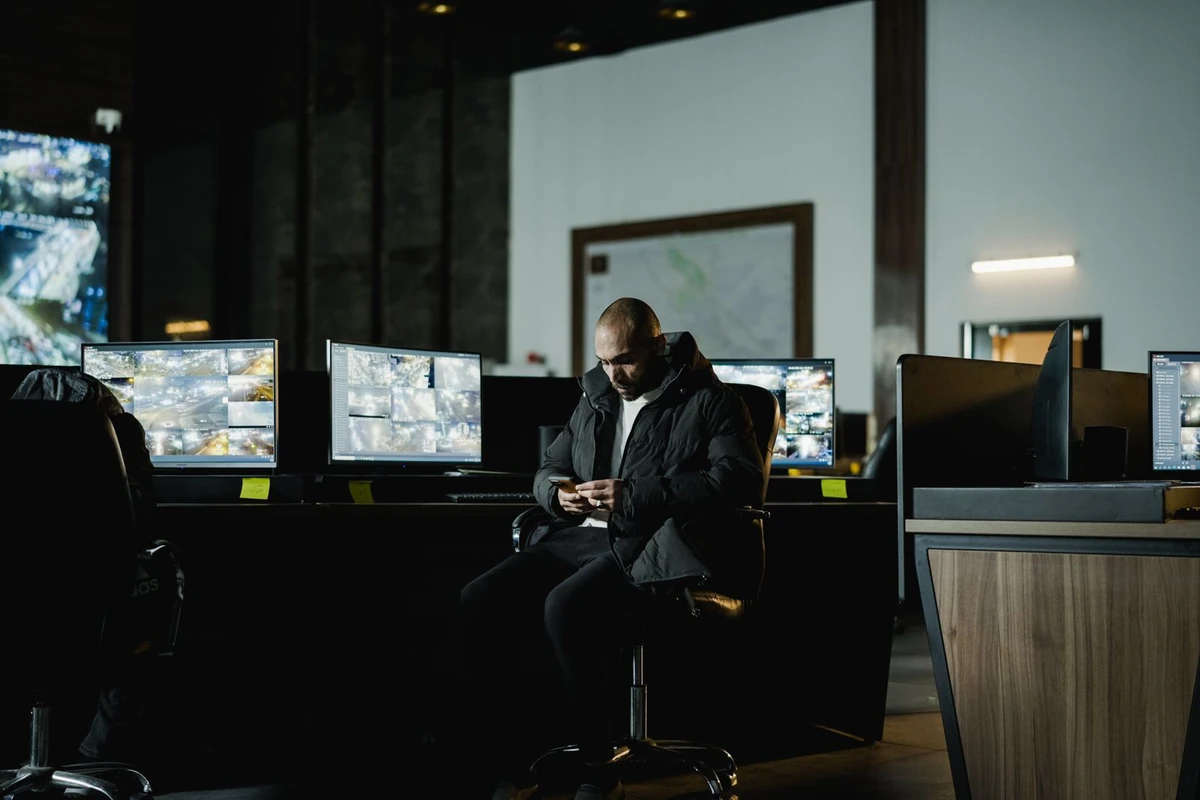 Security officer in a monitoring room with multiple screens